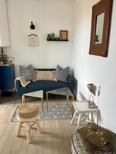 a living room with a blue couch and stool at Duplex plage des chalets Gruissan plage in Gruissan
