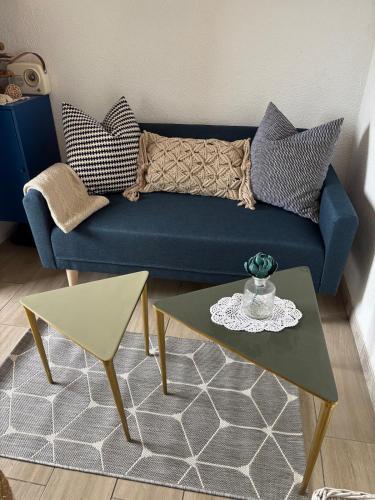 a living room with a blue couch and a table at Duplex plage des chalets Gruissan plage in Gruissan