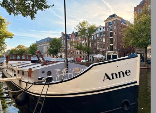 a boat docked in the water in a city at Canal Suite on Houseboat in Amsterdam