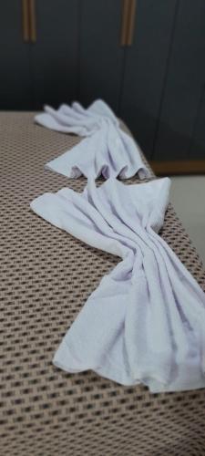 a pile of white towels sitting on a bed at Villas dos Pássaros in Porto Seguro