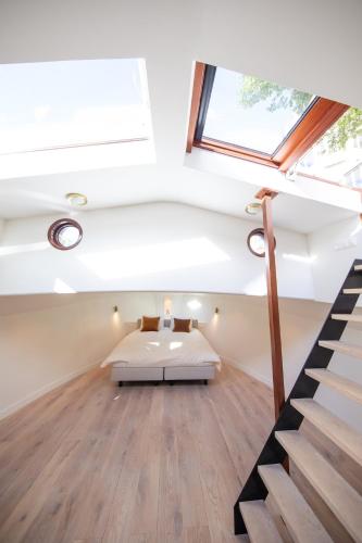 a bedroom with a bed in the middle of a room at Canal Suite on Houseboat in Amsterdam