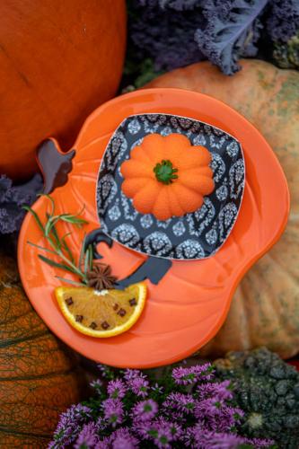 an orange bowl with a plate with a flower on it at Bajka Hotel & Resort in Grodziec