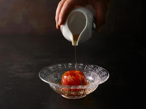 a person pouring honey into a bowl of food at JW Marriott Hotel Tokyo in Tokyo