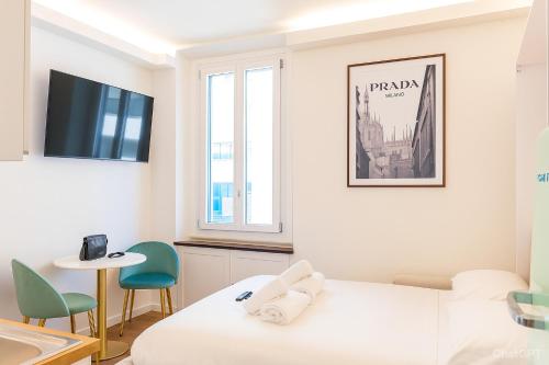 Habitación blanca con cama, mesa y sillas en Vecchia Milano Luxury Suite, en Milán