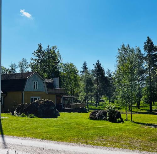 a house with two large rocks in front of a yard at Mark Villan in Örebro