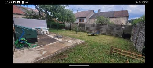 a backyard with a fence and a table and a bench at Maison 2 chambres doubles cour et jardin 