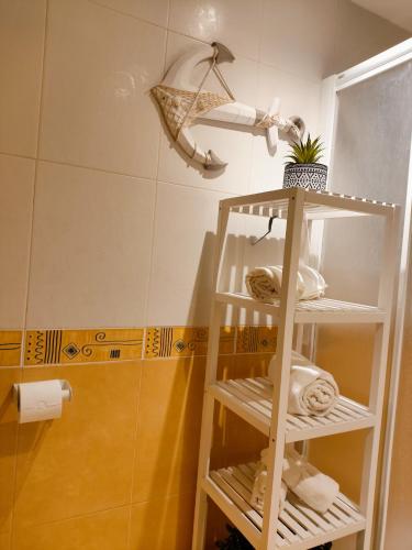 a bathroom with a towel shelf with towels at Flor de Lis in Medina de Pomar