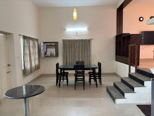 a dining room with a black table and chairs at Scenic Family Retreat in Kodai! Kodai Sierra in Kodaikānāl