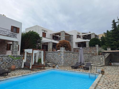 a villa with a swimming pool in front of a house at Malvazios Villas #4 in Gythio