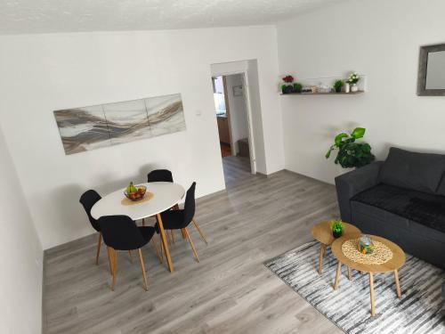 a living room with a couch and a table and chairs at Apartman Relax in Slavonski Brod