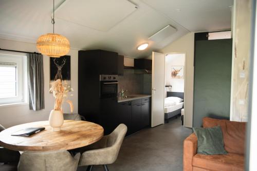 una cucina e una sala da pranzo con tavolo in una stanza di De Bijsselse Enk, Noors chalet 14 a Nunspeet