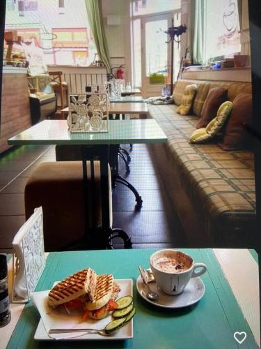 a table with a plate of food and a cup of coffee at Goodnight Amsterdam Lovely B&B in city centre-private-quiet-luxurious in Amsterdam
