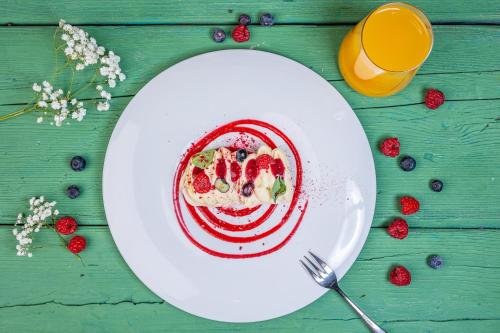 a plate of food with strawberries and fruit on a table at Kolumna Park Hotel in Dobroń