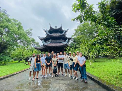 a group of people standing in front of a building at Tam Coc Mountain Sunset and Garden Hotel in Ninh Binh