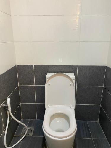 a bathroom with a white toilet in a tiled wall at My Service Suites Times Square KL in Kuala Lumpur