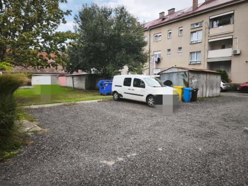 a white van parked in a parking lot next to a building at Apartman Relax in Slavonski Brod