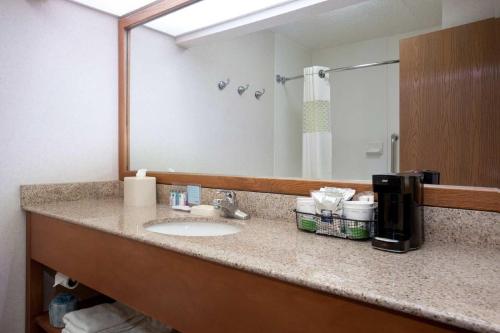 a bathroom counter with a sink and a mirror at Baymont by Wyndham Thornton in Thornton