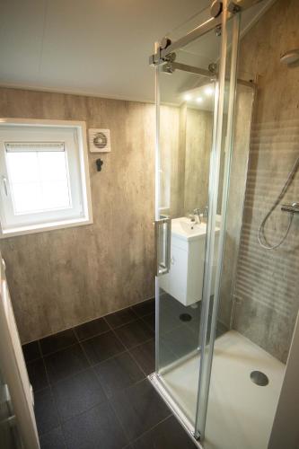 a bathroom with a shower and a sink at De Bijsselse Enk, Noors chalet 13 in Nunspeet