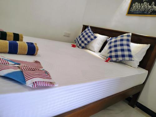 a bed with white sheets and pillows on it at Sunee'S Home Stay in Ahangama