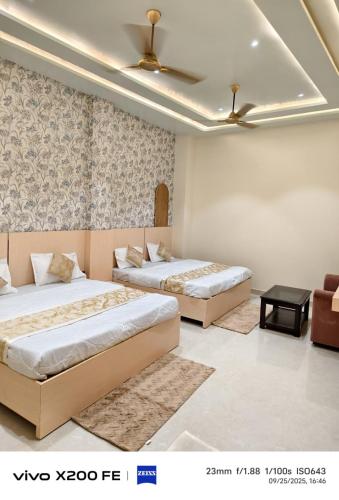 ein Schlafzimmer mit zwei Betten und einer Couch in der Unterkunft Knightz Bridge Hotel in Faizābād