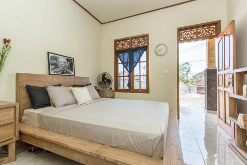 a bedroom with a bed and a clock on the wall at The Bali Boarding House in Uluwatu
