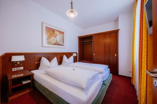 a bedroom with a large bed with white sheets at Hotel Seeperle in Langenargen