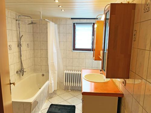 a bathroom with a tub and a sink and a bath tub at Landhaus-Villa, Sauna, private Garten in Schleiden