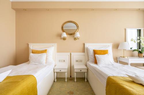 two beds sitting next to each other in a room at Calimbra Wellness Hotel Superior in Miskolctapolca