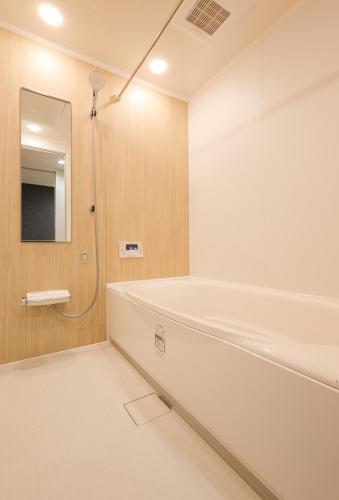 a white bathroom with a tub and a mirror at ZenKyoto in Kyoto