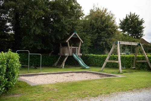 a park with a playground with two swings at De Bijsselse Enk, Noors chalet 4 in Nunspeet