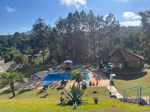 un groupe de personnes debout autour d'une piscine dans l'établissement Chácara Vovô João, à São Paulo