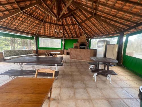 une chambre avec tables et bancs dans une cabane dans l'établissement Chácara Vovô João, à São Paulo
