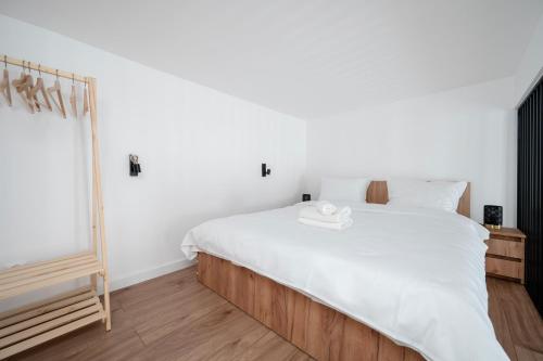 Un dormitorio con una cama blanca y un espejo. en Piotrkowska Luxury Studio with Mezzanine by BookingHost, en Łódź