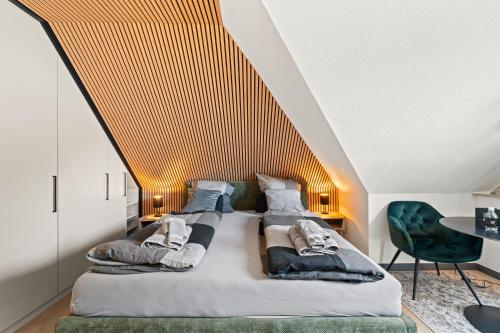 a bedroom with a large bed with a sloped ceiling at 10 Rooms City Apartments in Emden