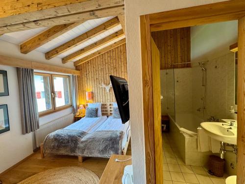 a bedroom with a bed and a tub and a sink at Victoria Retreat & Spa in Vercorin
