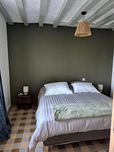 a bedroom with a bed with a green wall at Gîte de la Coup'Neuve in Chemilli