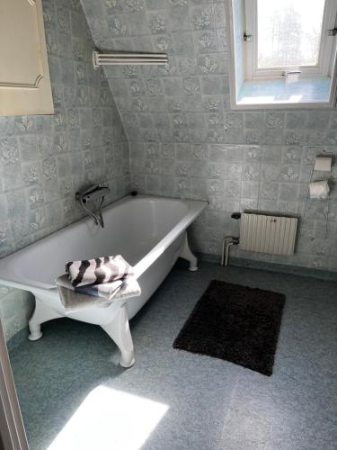a white bath tub in a bathroom with a window at Mark Villan in Örebro