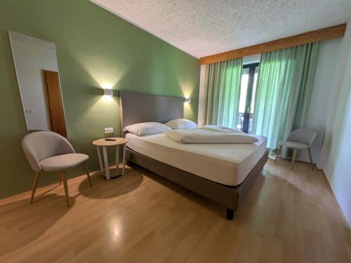 a bedroom with a bed and a table and chairs at Garni Saltneregg Ferienwohnungen in Caldaro