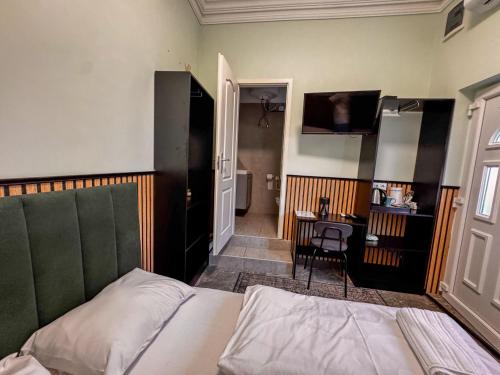 a bedroom with a bed and a desk and a room at Cozy Modern Studio in Debrecen