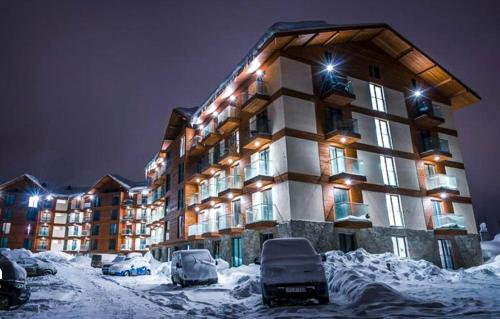 a large building with cars parked in the snow at New Gudauri Panorama View Loft II in Gudauri