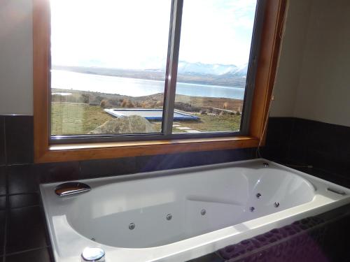 a bath tub in a bathroom with a window at Isolation Bay in Lake Tekapo