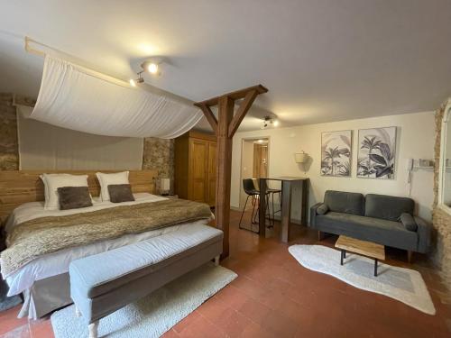 una camera da letto con un letto, un divano e un tavolo di Le St Vincent a Roquefort