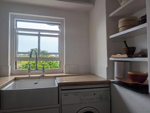a kitchen with a sink and a window at Charming 2 bedroom Cottage near Skibbereen with stove and views 