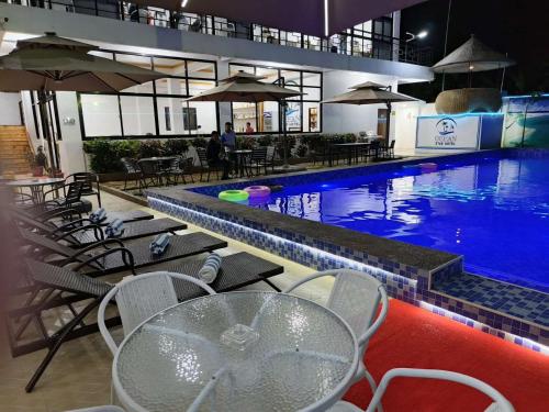 a swimming pool with a table and chairs next to it at Ocean Star Hotel Coron in Coron