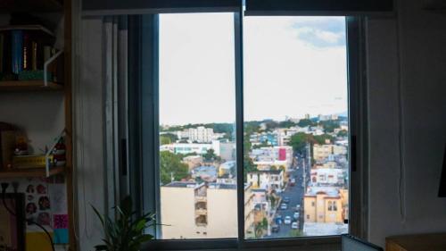 a view of a city from a window at The Alexa tiny apartment city view in San Juan