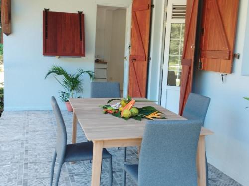 a wooden table with a bunch of vegetables on it at Villa Heliconia à 10 min des plages et des tortues in Les Anses-dʼArlets