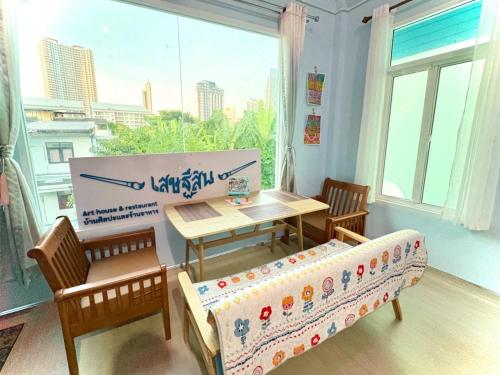 a living room with a table and a couch and a window at Setthisin Art Boutique House,Iconsiam,BTS Thonburi in Godown