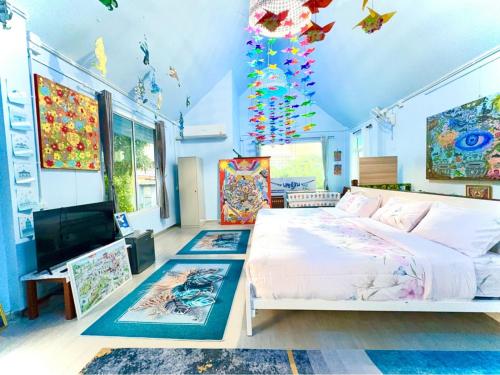 a bedroom with a bed and a flat screen tv at Setthisin Art Boutique House,Iconsiam,BTS Thonburi in Godown