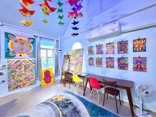 a room with a table and chairs and paintings on the wall at Setthisin Art Boutique House,Iconsiam,BTS Thonburi in Godown