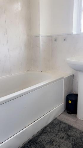 a white bath tub next to a sink in a bathroom at Home in Colchester in Colchester